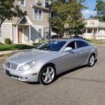 Mercedes-Benz CLS 550 in brilliant silver with black leather interior parked on the street, ready for sale.