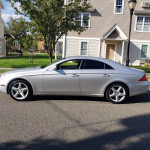 Silver Mercedes-Benz CLS 550 parked on the street, showcasing sleek design and excellent condition.
