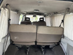 Interior of a 1995 Nissan Homy van showcasing seating arrangements and curtains.
