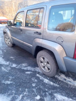2012 Jeep Liberty Sport RWD parked on snowy surface, showcasing its excellent condition and features.