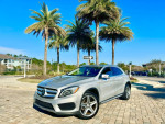 2015 Mercedes-Benz GLA 250 4MATIC AWD parked among palm trees, showcasing its stylish design and features.