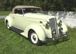 Classic 1936 Packard 120B convertible coupe parked on grass with a beige convertible top.
