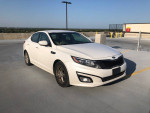 2015 Kia Optima in white parked on a rooftop, showcasing its clean design and new tires.