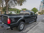 2021 Ford F250 Lariat Super Duty 4x4 in black, showcasing luxury features and powerful turbo diesel engine.