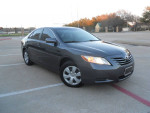 2009 Toyota Camry LE in gray color parked, featuring leather interior and low mileage of 122,000.