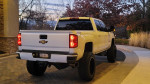 Rear view of a lifted 2019 Chevrolet Silverado 2500 with custom wheels and tires parked outdoors