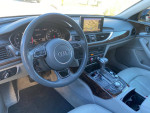 Interior view of a 2012 Audi A6 showing dashboard, steering wheel, and control panel with navigation system.
