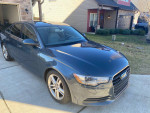 2012 Audi A6 in grey color, parked in a driveway, requiring transmission repair but in good condition