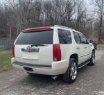 2007 Cadillac Escalade with chrome wheels, parked, showcasing its white exterior and rear features.