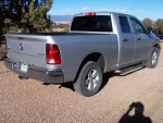 Silver 2015 Ram 1500 truck parked outdoors, showcasing its good condition and hitch features.