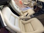Interior view of a 1980 Chevrolet Corvette showcasing white leather seats and stylish dashboard.