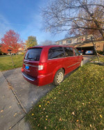 2014 Chrysler Town & Country Mini Van parked in driveway with autumn foliage