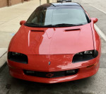 Front view of a pristine 1997 Chevrolet Camaro RS, showcasing polished rims and vibrant paint.