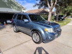 2011 Ford Escape Limited FWD parked in driveway, showcasing its blue exterior and chrome wheels.