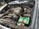2001 Toyota Tacoma PreRunner RWD engine compartment with battery and various parts visible.