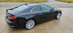 2018 Audi A5 Premium Plus coupe, black with sleek design, parked on a driveway, showcasing its elegant profile.