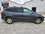 2011 Chevrolet Traverse in gray color, parked outside Surplus USA, showing side view.