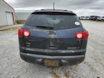 Back view of a gray 2011 Chevrolet Traverse with wear and tear for sale at Surplus USA.