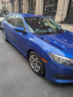 2016 Honda Civic LX in blue, parked on city street, showcasing its compact design and clean condition.