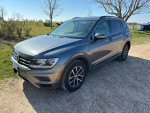 2018 Volkswagen Tiguan SE 4Motion AWD in gray, parked outdoors near a grassy area.