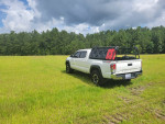 2021 Toyota Tacoma TRD off-road truck parked in a grassy field, showcasing its clean exterior and accessories.