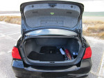 Open trunk of a black 2011 BMW 328i XDrive with neatly arranged storage.