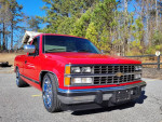 Red 1989 Chevrolet C1500 Silverado Pickup with chrome wheels parked outdoors