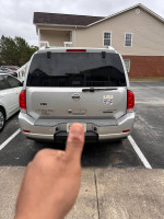 Rear view of a 2011 Nissan Armada Platinum Edition in a parking lot with a thumbs up gesture.