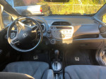 Interior view of a 2010 Honda Fit Sport, showcasing dashboard and steering wheel features.