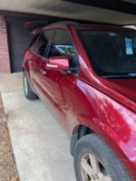 2011 Chevrolet Traverse LS in burgundy with dark gray interior parked in a garage, showcasing exterior and side view.