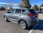 2017 Hyundai Tucson SUV in gray color, parked outdoors showcasing its design and condition with minor scratches.