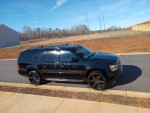 Black 2009 Chevrolet Suburban LTZ 4WD with new paint job and factory wheels parked on the street
