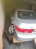 Damaged 2005 Honda Accord with missing rear tire, showcasing accident damage to body and interior.