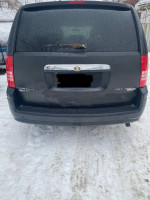 Rear view of a 2009 Chrysler Town & Country van with 153k miles, showing its durable condition and functional features.