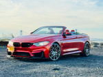 2015 BMW M4 Convertible in red with alloy wheels, showcasing its sleek design and luxury features.