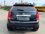Rear view of a 2015 Cadillac SRX Premium in black, showcasing its sleek design and exhaust features.
