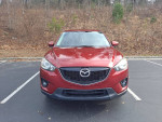 Front view of a 2013 Mazda CX-5 parked, showcasing its shiny red exterior and stylish design.