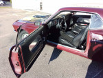 Interior of a 1969 Ford Mustang Mach 1 with black leather seats and open door