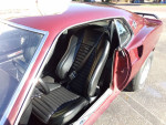 Interior view of a 1969 Ford Mustang Mach 1 with black seats and open door.