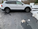 Side view of a 2018 Volkswagen Tiguan parked on a snow-covered driveway.