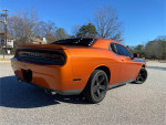 2011 Dodge Challenger in bright orange color, showcasing its sleek design and aftermarket modifications.