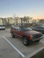 Classic Jeep Wagoneer with burgundy trim, parked in an outdoor lot, showcasing solid condition and original mileage.