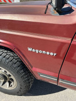 Close-up of a Jeep Wagoneer showcasing the burgundy trim and solid tire tread.