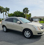 2010 Cadillac SRX luxury edition parked with lush greenery, showcasing its immaculate condition and stylish design.