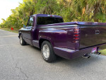 Custom 1971 Chevy C10 Shortbed Stepside truck with purple paint parked on a road