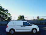 2013 Ram C/V Cargo Van with roof racks side view, parked in clear blue sky