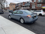 2010 Nissan Altima Hybrid sedan in blue parked on the street, featuring a clean exterior and good tires.