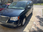 2009 Chrysler Town & Country parked in driveway, showcasing clean exterior and stow-and-go seating feature.