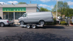 Silver Dodge B300 EV truck on a trailer at a car wash location in Illinois