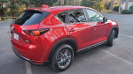 2017 Mazda CX-5 SUV in red with leather interior, sunroof, and heated seats, parked in a scenic area.